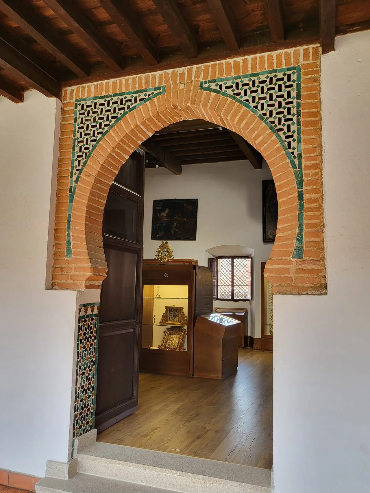 Arco de herradura mudéjar de ladrillo con alfiz y azulejos, resto del palacio del siglo XIV