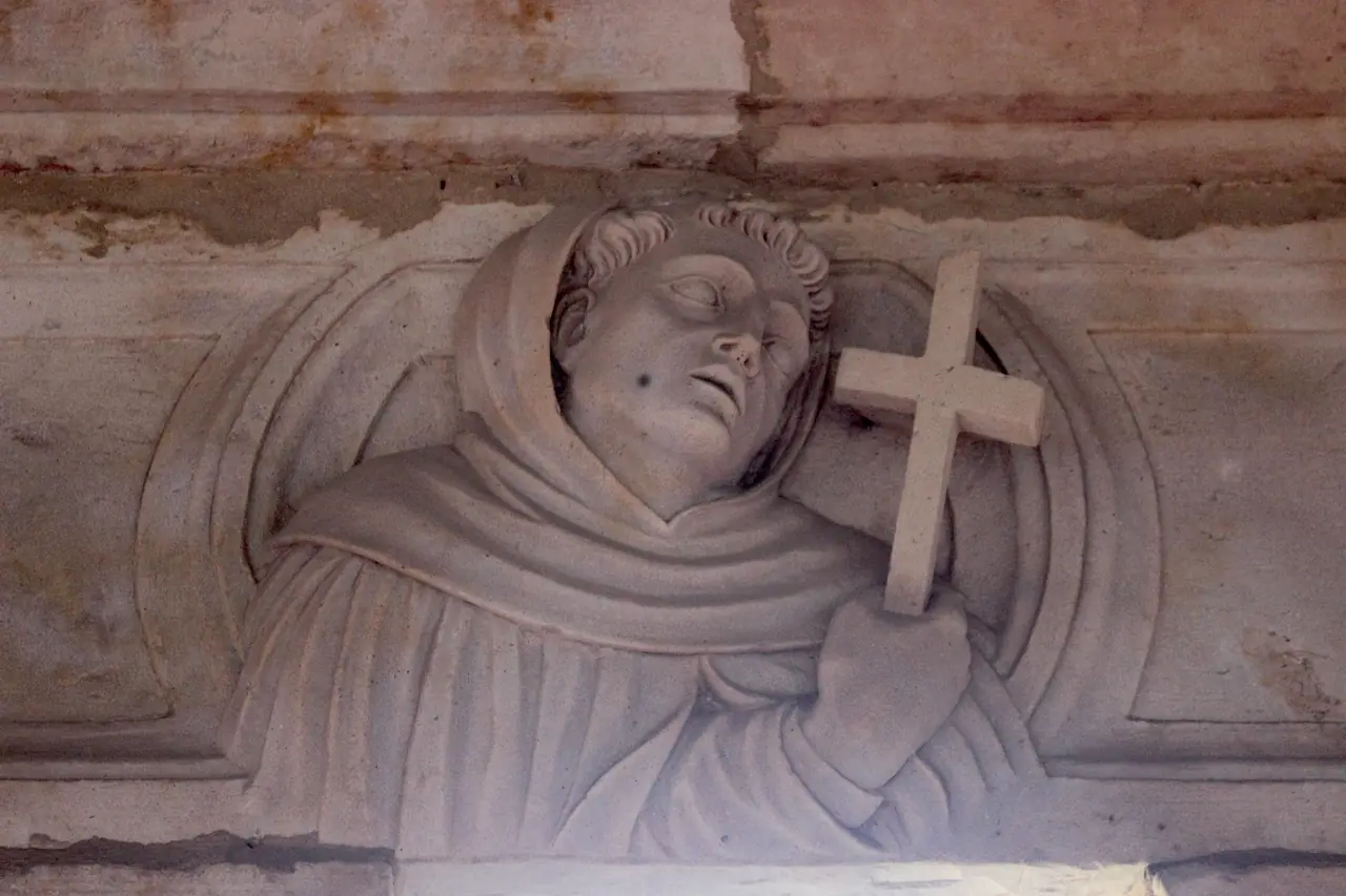 Medallón con una figura que sostiene una cruz
